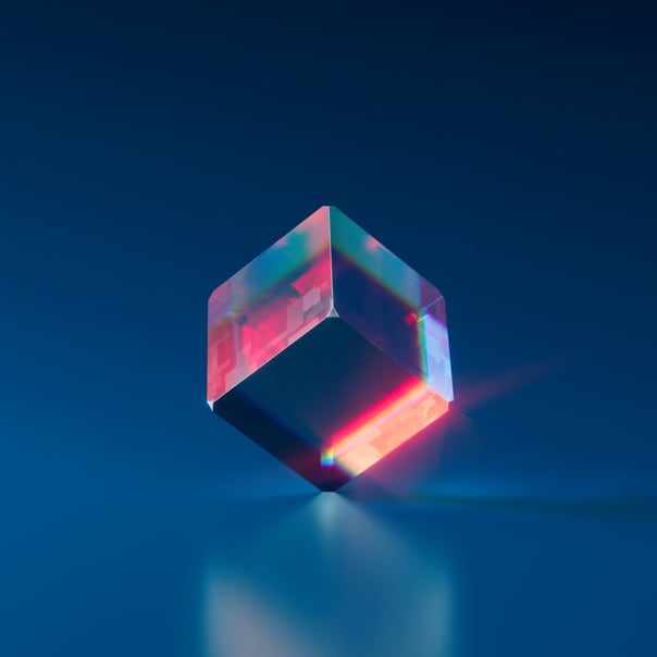 A translucent cube with pink reflections balanced on one side